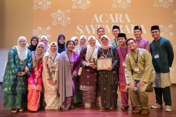 Tetamu terhormat, Canselor Universiti Sains Kemasyarakatan Singapura (SUSS) yang juga mantan Presiden Singapura, Puan Halimah Yacob (barisan hadapan, tiga dari kanan), bersama anggota jawatankuasa Bisikan Pena semasa acara Sayembara Bisikan Pena 2024 yang diadakan di Auditorium Perpustakaan Daerah Woodlands pada 6 Julai. 