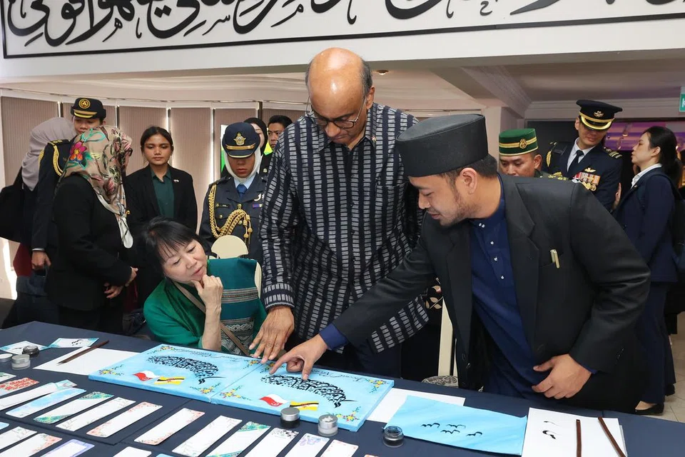 MEMPELAJARI BUDAYA: Presiden Tharman Shanmugaratnam (tengah) dan isterinya, Cik Jane Ittogi Shanmugaratnam (duduk) diberi taklimat oleh pegawai Pusat Pengajian Kaligrafi dan Seni Islam Yayasan Sultan Haji Hassanal Bolkiah tentang kaligrafi tulisan Jawi pada 26 Januari.