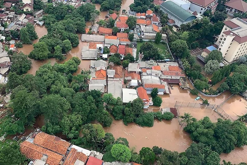 TERJEJAS TERUK: Banjir di Jakarta hampir menenggelamkan rumah-rumah rendah di kawasan bandar itu. - Foto AFP/BNPB