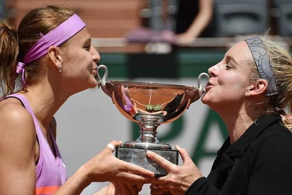 GANDINGAN HEBAT: Bethanie Mattek-Sands (paling kanan) dan Lucie Safarova mencium trofi kejuaraan Terbuka Perancis yang dimenangi mereka di Rolland Garros pada Jun lalu. - Foto AFP