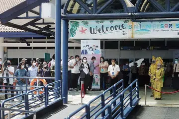 KETIBAAN DISAMBUT MERIAH: Kumpulan pertama pengunjung dari Singapura selamat tiba dan disambut meriah di terminal feri Bandar Bentan Telani di Bintan pada hari pertama pelancaran VTL SG-Bintan kelmarin. - Foto BM oleh KHALID BABA
