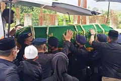 DIKEBUMIKAN: Anggota unit polis elit Indonesia, Briged Bergerak, membawa keranda semasa upacara pengebumian Emmeril Kahn Mumtadz, anak gabenor Jawa Barat, di Kabupaten Bandung kelmarin. - Foto KOMPAS.COM
