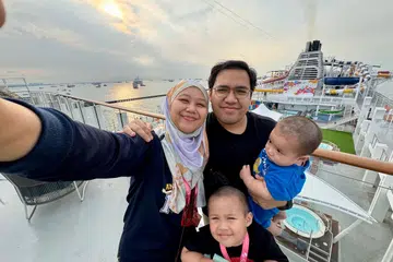 Penulis, Cik Nur Humaira Sajat (kiri), bergambar di tingkat atas kapal persiaran Genting Dream bersama suami, Encik Jefnilham Jamaludin, serta anak-anaknya, Muhammad Uwais Jefnilham dan Muhammad Ihsan Jefnilham (kanan).
