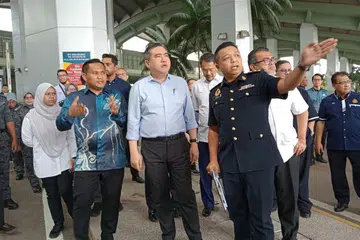 MUDAHKAN ORANG RAMAI: Menteri Pengangkutan Malaysia, Encik Anthony Loke (berkemeja biru), meninjau Kompleks Kastam, Imigresen dan Kuarantin (CIQ) Kompleks Sultan Abu Bakar (KSAB) di Iskandar Puteri, Johor, pada 11 Januari.