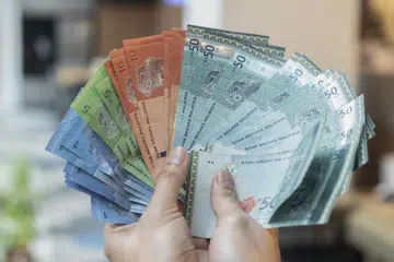 RINGGIT SUSUT: Orang ramai mengambil kesempatan menukar dolar Singapura ke ringgit pada pagi Jumaat setelah mata wang Malaysia merosot ke paras terendah.