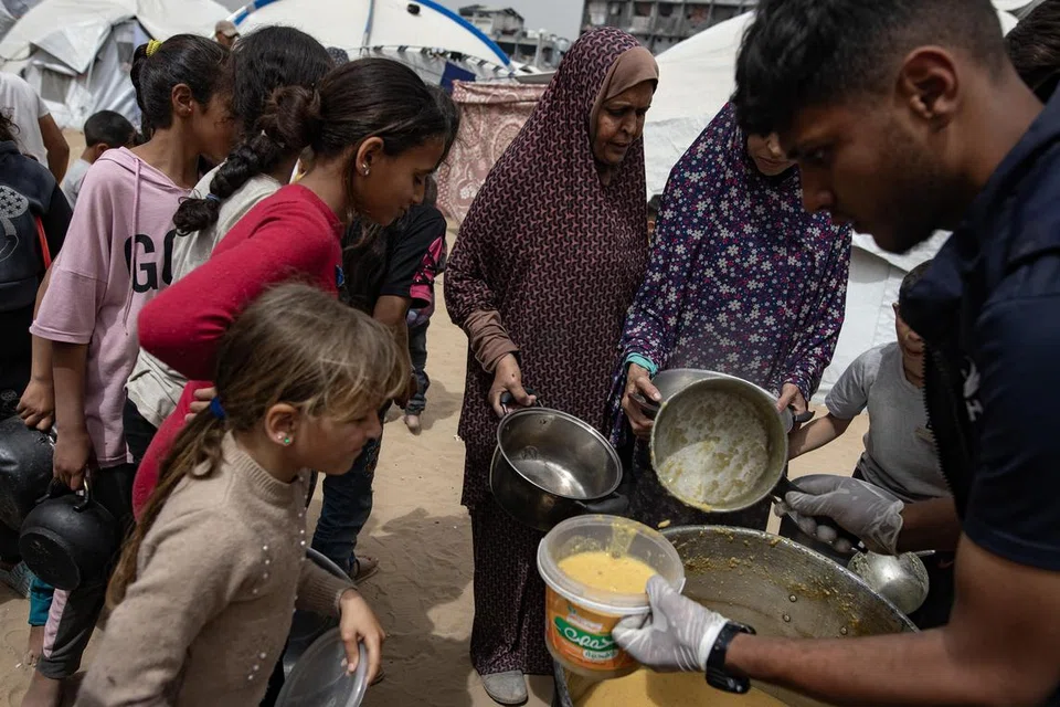Rakyat Palestin yang dipindahkan berkumpul untuk mendapatkan bekalan makanan yang disumbang badan amal di kem pelarian Jabalia, di utara Jaluran Gaza.