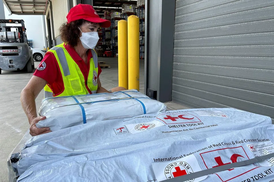 SIAPKAN BARANGAN: Bekalan bantuan sedang disiapkan oleh kakitangan Palang Merah Australia di Brisbane, Australia (gambar atas), untuk dihantar ke Tonga. - Foto REUTERS 