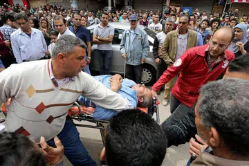 MENGUSUNG MANGSA: Seorang mangsa dikejarkan ke ambulan selepas sebutir bom meletup di di Gereja Koptik di Tanta, Mesir pada 8 April lalu. - Foto REUTERS