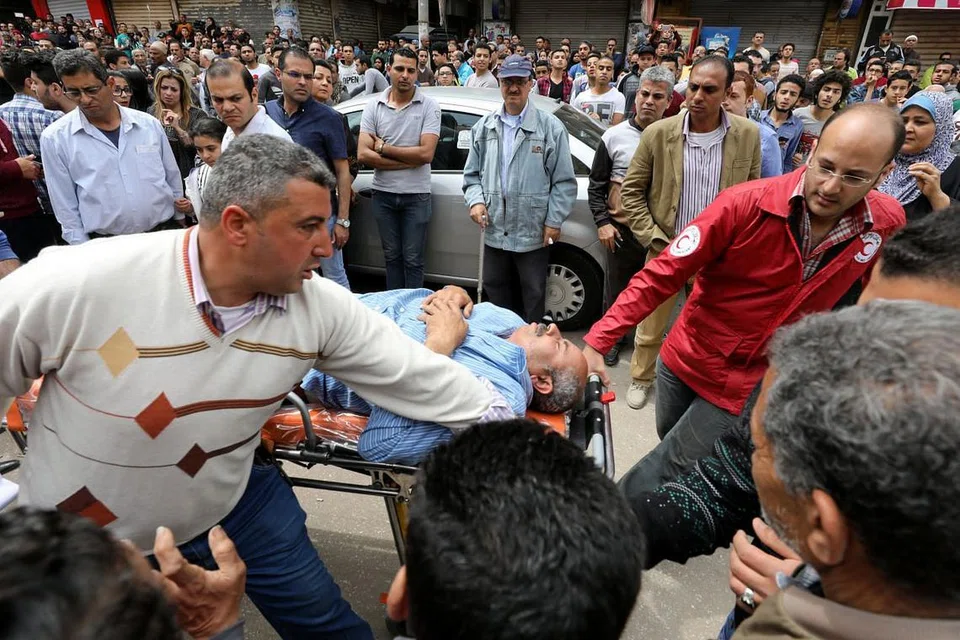 MENGUSUNG MANGSA: Seorang mangsa dikejarkan ke ambulan selepas sebutir bom meletup di di Gereja Koptik di Tanta, Mesir pada 8 April lalu. - Foto REUTERS