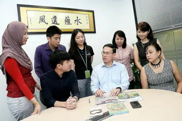 BINCANG CARA TARIK PENYERTAAN MASYARAKAT: Dr Teo (berkemeja cerah, tengah) berbincang dengan kakitangan CDC North West cara terbaik mengendalikan aktiviti untuk menarik minat masyarakat di kawasan itu.