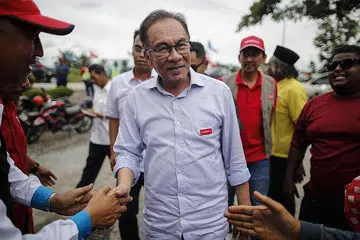 PERCATURAN POLITIK: Datuk Seri Anwar (depan) berkata Pakatan Harapan sudah lama menyedari rancangan dan rundingan antara Umno, PAS dan Bersatu untuk bergabung dan membentuk kerajaan baru. Gambar menunjukkan beliau bersama penyokongnya semasa berkempen di Sekinchan, Selangor. - Foto EPA-EFE