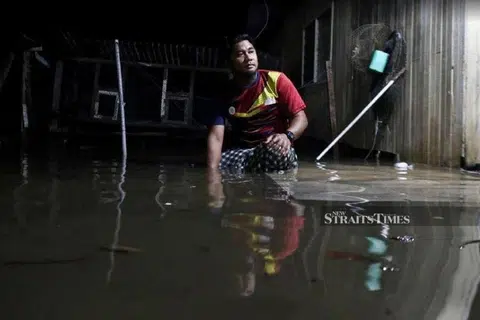 DITENGGELAMI AIR: Seorang penduduk Terengganu melihat keadaan rumahnya yang dimasuki dan ditenggelami air. - Foto NST