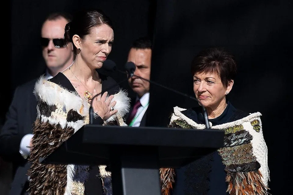 BERDIRI BERSAMA MANGSA: Cik Ardern (kiri) bersama ribuan orang memperingati 50 mangsa kes tembakan di dua masjid di New Zealand di satu upacara di Hagley Park di Christchurch semalam. - Foto AFP