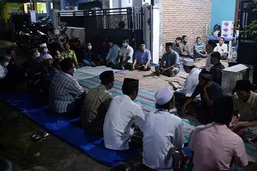 MENGADAKAN TAHLIL: Gambar yang dirakamkan pada 25 April menunjukkan orang ramai berhimpun di rumah Encik Ede Pandu Yudha Kusuma, yang merupakan salah seorang anak kapal KRI Nanggala 402 semasa ia hilang pada 21 April lalu sebelum ia disahkan tenggelam bersama-sama 53 kakitangannya di Banyuwangi, Jawa Timur. - Foto AFP 