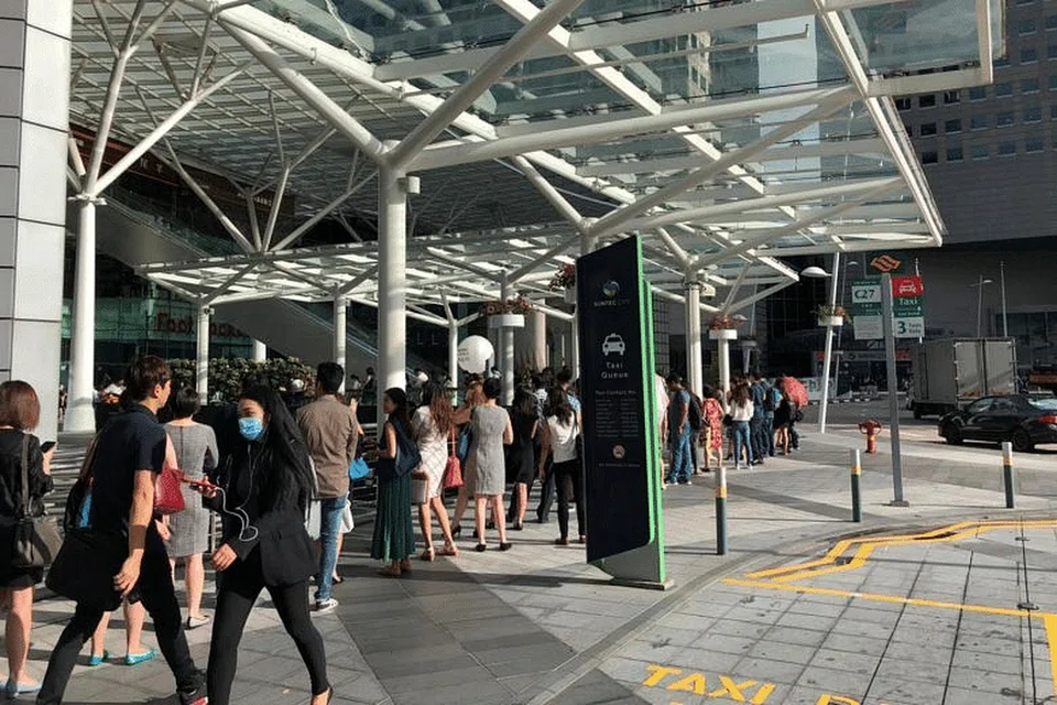 Orang ramai beratur untuk mengambil suhu badan di Suntec City Isnin ini. - Foto BH oleh CHONG JUN LIANG