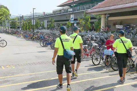 DEKATI MASYARAKAT: Pasukan penguatkuasaan meronda kawasan sekitar stesen MRT Yishun semalam demi memberi maklumat kepada penunggang yang meletakkan basikal di situ. - Foto BH oleh JONATHAN CHOO