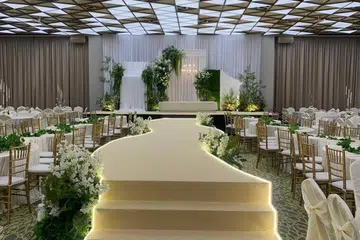 Pentas menuju ke pelamin yang dihiasi bunga dan limpahan cahaya menyerikan suasana majlis perkahwinan yang ditawarkan Muslim Delights Wedding Services.