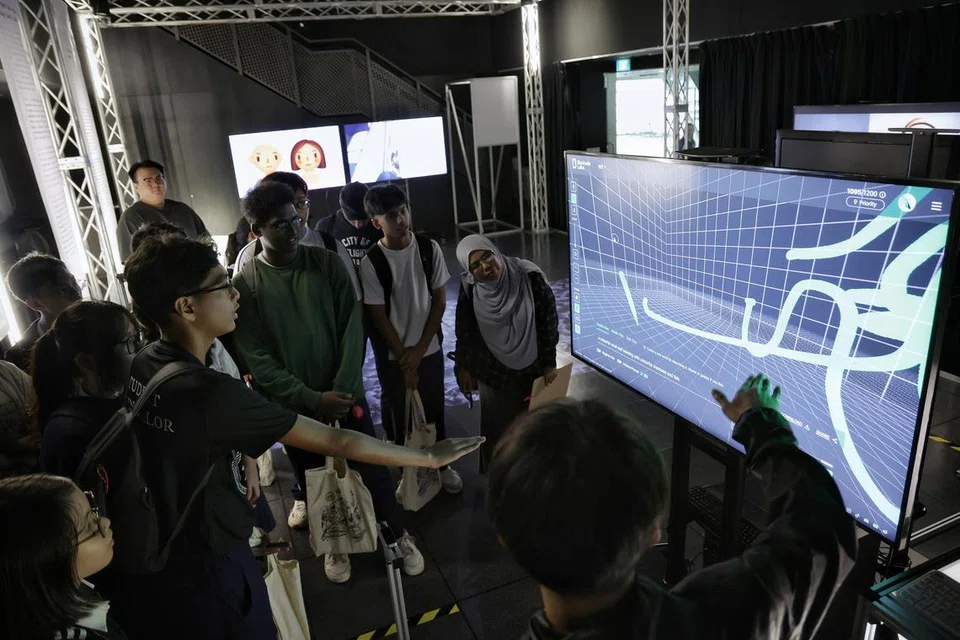TEROKA AI: Pelajar sekolah menengah yang mengunjungi Studio Eksperimen Digital Interaktif dengan AI (Ideas) semasa Rumah Terbuka Politeknik Temasek pada 4 Januari mencuba peralatan kecerdasan buatan (AI) untuk menghasilkan lukisan digital.