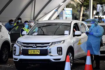 LANGKAH PENJAGAAN SELAMAT DIPERKETAT SEMULA: Kakitangan kesihatan merekodkan butiran penduduk di hentian pandu lalu ujian Covid-19 di Bondi Beach di Sydney kelmarin selepas tersebar jangkitan baru. - Foto AFP