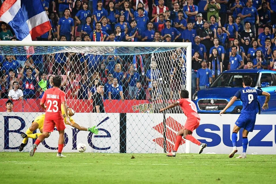 HAPUS SUDAH IMPIAN: Penyerang Thailand, Adisak Kraisorn (kanan), menjaring gol ketiga pasukan rumah yang melenyapkan impian Singapura untuk melangkah ke peringkat separuh akhir. - Foto BH oleh CHONG JUN LIANG
