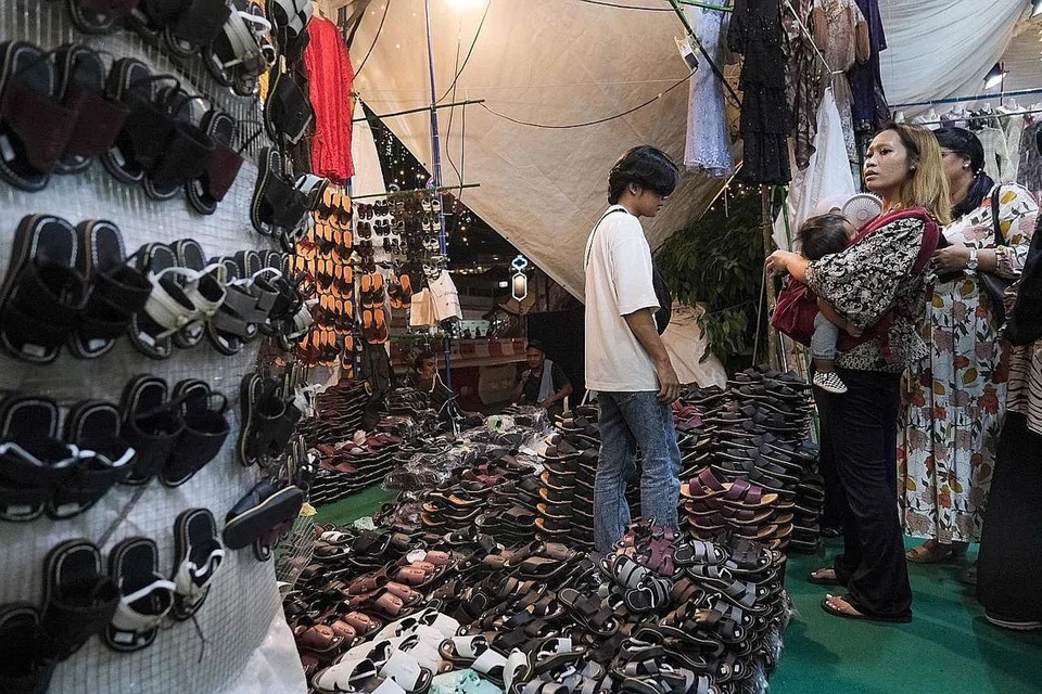 PILIHAN RAMAI: Pelanggan dilihat sibuk membeli kebab, antara makanan kegemaran ramai yang biasanya dibeli di bazar setiap tahun. Sementara itu, seorang pelanggan pula dilihat sedang meninjau capal.