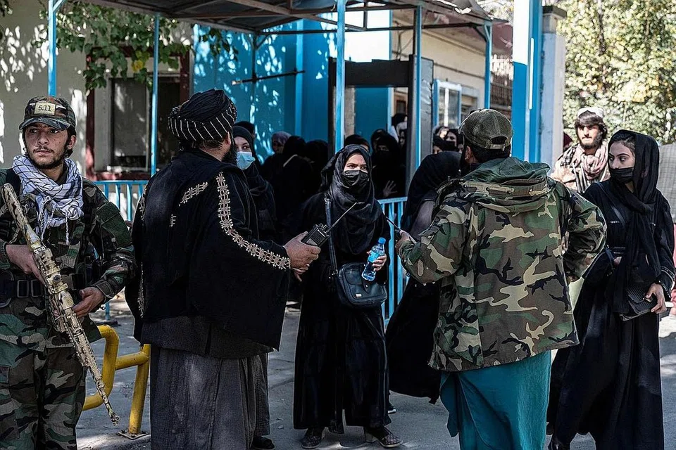 DIKAWAL RAPI: Askar Taleban mengawal ketat pelajar perempuan yang tiba di Universiti Kabul bagi menduduki peperiksaan penilaian untuk memasuki universiti tersebut kelmarin. - Foto AFP