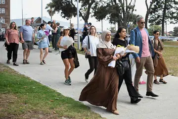 Orang ramai membawa bunga untuk diletakkan di tugu peringatan sementara menyusuli kejadian tembakan di Pantai Bondi di Sydney pada 15 Disember 2025.