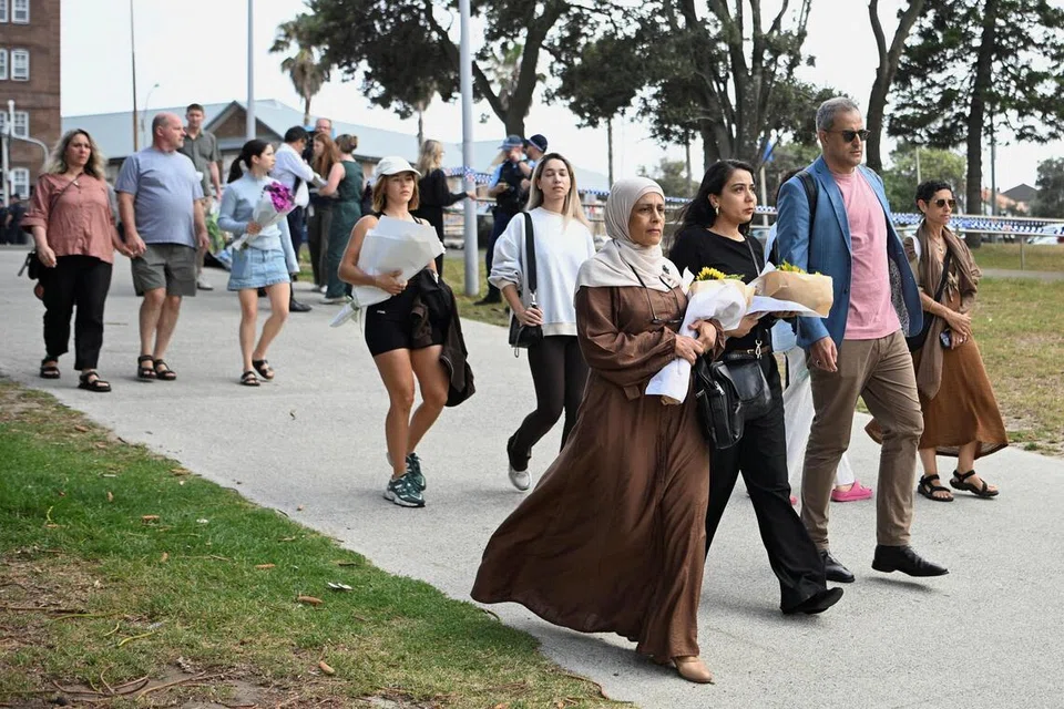 Orang ramai membawa bunga untuk diletakkan di tugu peringatan sementara menyusuli kejadian tembakan di Pantai Bondi, di Sydney, Australia, pada 15 Disember 2025.