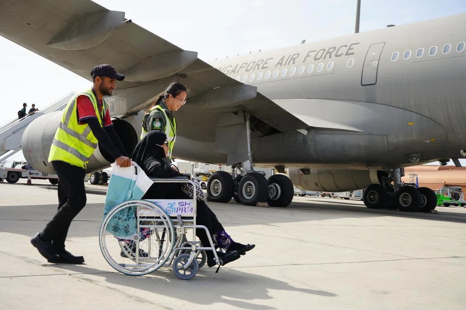 Pegawai Perubatan Penerbangan SAF membantu penumpang berkerusi roda menaiki Pesawat Pengangkutan Tangki Pelbagai Peranan (MRTT) A330 di Lapangan Antarabangsa Antarabangsa Raja Abdulaziz, Arab Saudi pada 12 Mac. 