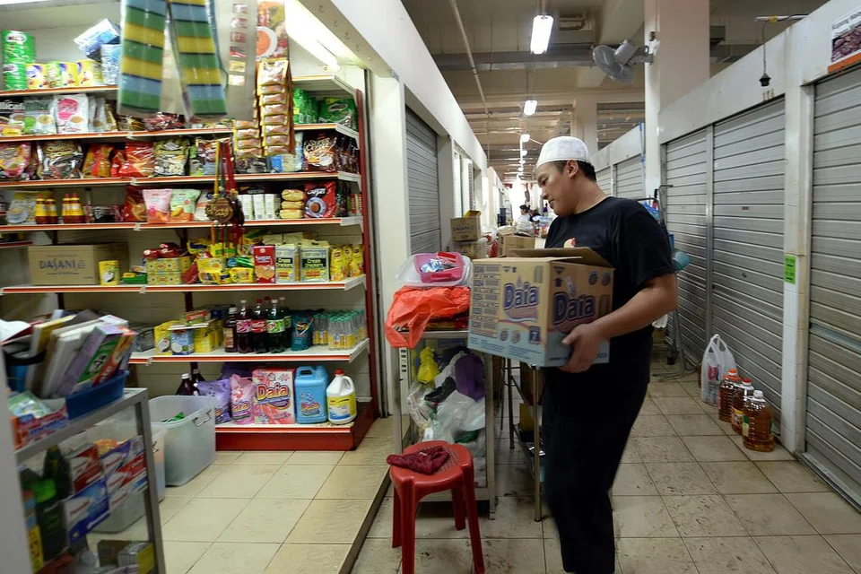 SIBUK MEMBERSIHKAN KEDAI: Dari awal minggu ini lagi, pegerai di Pasar Geylang Serai sudah mula membersihkan kedai mereka bagi pembukaan semula pasar itu, esok. - Foto ZAINAL YAHYA