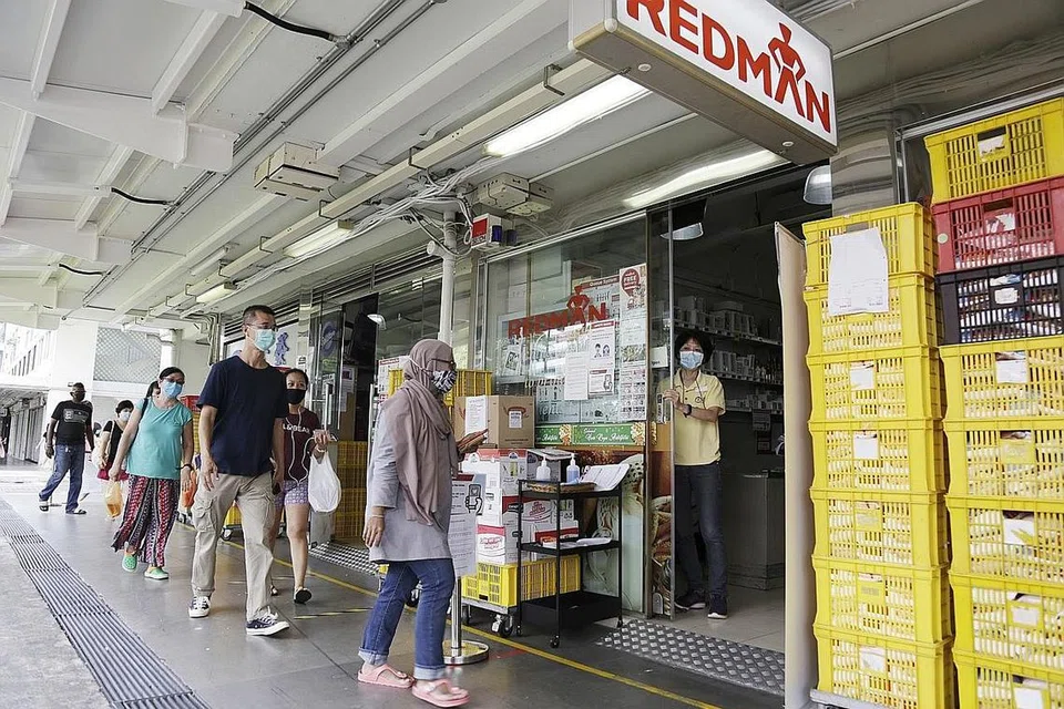 BARISAN PANJANG: Pelanggan di kedai menjual keperluan membuat kuih, kek dan biskut, Phoon Huat di Blok 107 Toa Payoh Lorong 1 perlu menunggu giliran, diperiksa suhu badan dan kad pengenalan sebelum dibenarkan berbelanja di dalam. - Foto BM oleh AZMI ATHNI