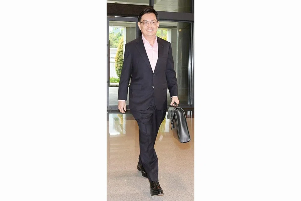 SAMPAIKAN BAJET: Encik Heng tersenyum sebaik tiba bagi menyampaikan Bajet awal tahun ini. Bajet itu disifatkan Perdana Menteri Lee Hsien Loong sebagai salah satu yang bukan sahaja memenuhi keperluan generasi hari ini, malah menyumbang kepada keperluan generasi akan datang. - Foto fail