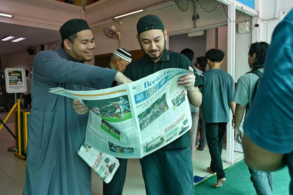 Anggota jemaah Masjid Darussalam, Encik Muhd Naufal Mohd Diah (kanan), membaca siri ‘Masjid Kita’ yang dicetak di akhbar Berita Harian (BH) pada 17 Januari. Beliau ditemani pegawai dakwah Masjid Darussalam, Ustaz Ahmad Shakir Mohammad Zamri. 