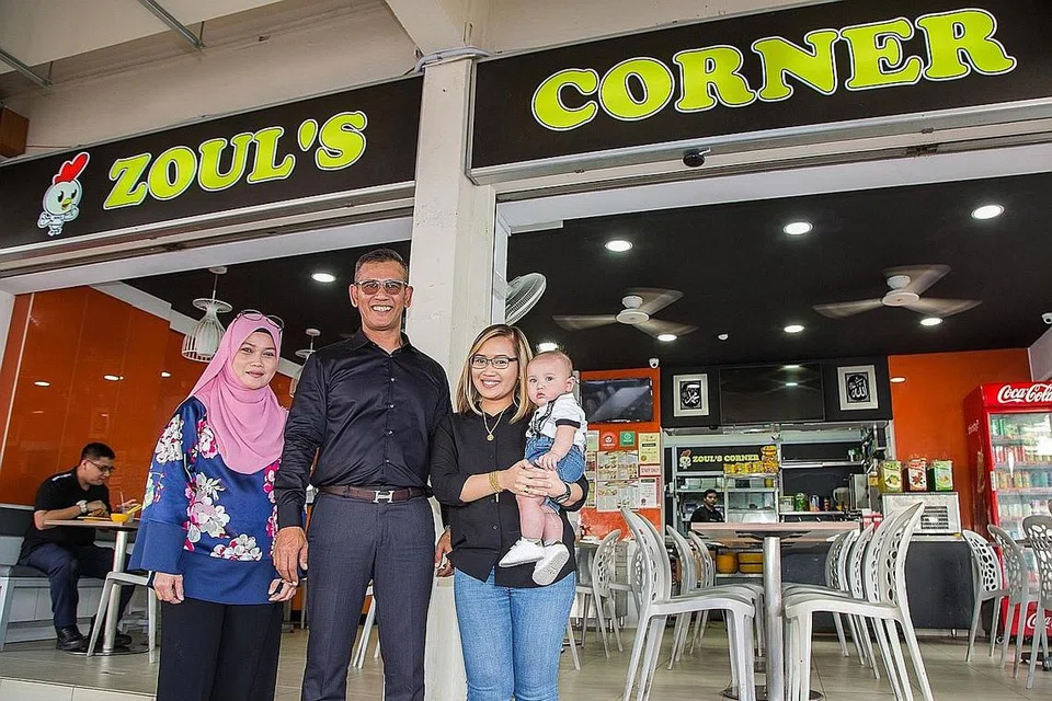 PUJIAN SEBAGAI BONUS: Encik Azhar Mohd Salleh, atau lebih dikenali sebagai Zul (berkemeja hitam), turut menerima kunjungan pelanggan dari Medan, Bandung dan Surabaya. Dari kiri ialah isterinya yang dikenali sebagai Cik Nelly, anak perempuannya, Nur Syafiqah, yang mendukung cucu Encik Azhar. - Foto BM oleh ZALEHA ABDUL KADIR