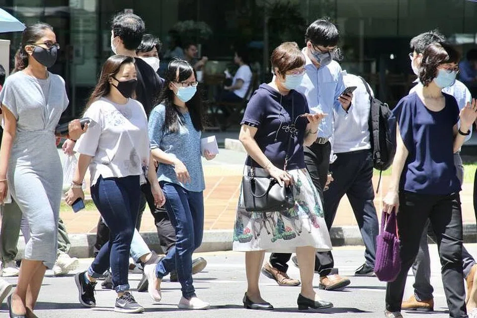 PERJUANGAN DITERUSKAN: Penduduk Singapura yang berpelitup dalam perjalanan ke tugasan masing-masing terus berjuang dengan sekitaran serba berubah dek pandemik Covid-19. - Foto FAIL CHINESE MEDIA GROUP