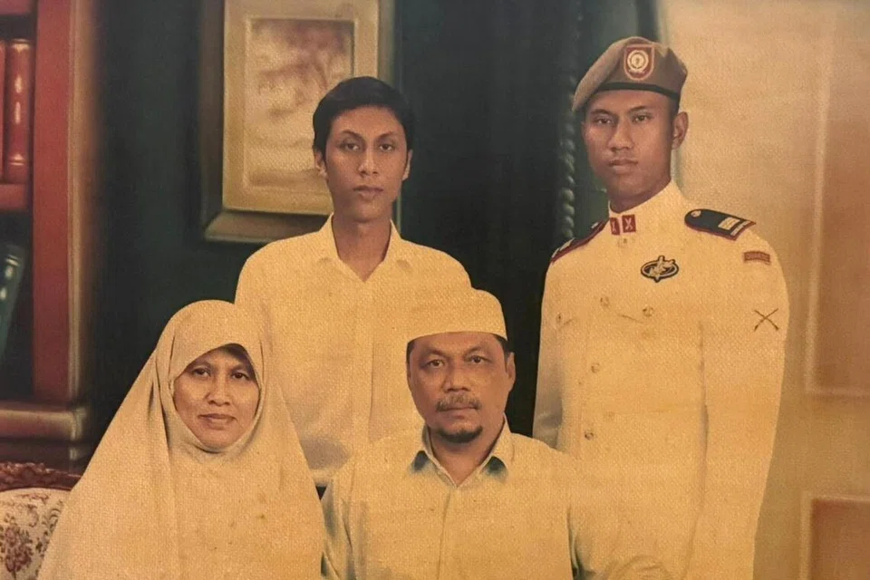 Brigedier Jeneral (BG) Fairoz Hassan (berdiri, kanan) bergambar dengan keluarganya sekitar 2002. Beliau diapit abangnya, Encik Herman Hassan, bersama ibu, Cik Sukini Sajari, dan bapa, Encik Hassan Haron.