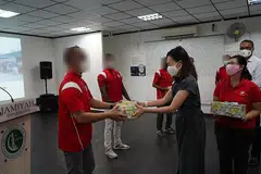 TERIMA HABUAN: Seorang penghuni Darul Islal, Encik Ahmad (bukan nama sebenar), menerima kotak hadiah daripada AP GRC West Coast, Cik Rachel Ong, dengan disaksikan pengerusi Interlace Resident Network, Cik Joyce Mehar (kanan). - Foto JAMIYAH SINGAPURA