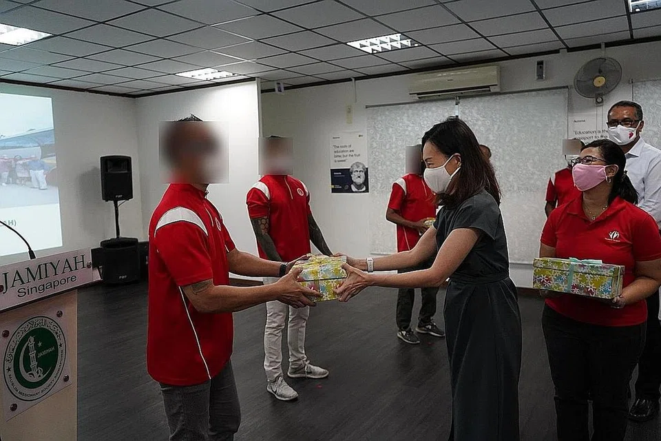 TERIMA HABUAN: Seorang penghuni Darul Islal, Encik Ahmad (bukan nama sebenar), menerima kotak hadiah daripada AP GRC West Coast, Cik Rachel Ong, dengan disaksikan pengerusi Interlace Resident Network, Cik Joyce Mehar (kanan). - Foto JAMIYAH SINGAPURA