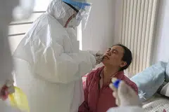 AMBIL SAMPEL: Seorang pekerja kesihatan sedang mengambil sampel daripada seorang pesakit bagi menguji kehadiran koronavirus baru di wilayah Shandong di timur China. - Foto AFP