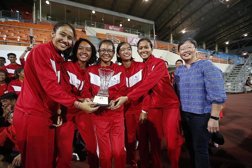 MUNCUL JUARA: Kuartet 4x100 meter Sekolah Sukan Singapura dan editor sukan 'The Straits Times,' Cik Lee Yulin bergambar dengan piala kemenangan. - Foto BH oleh TIMOTHY DAVID
