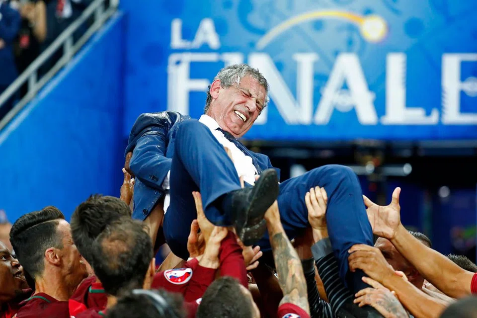 DIJULANG KEJAYAAN: Jurulatih Portugal, Fernando Santos, dilambung anak didiknya menyusuli kejayaan kelab negara itu mengalahkan Perancis 1-0. - Foto REUTERS 