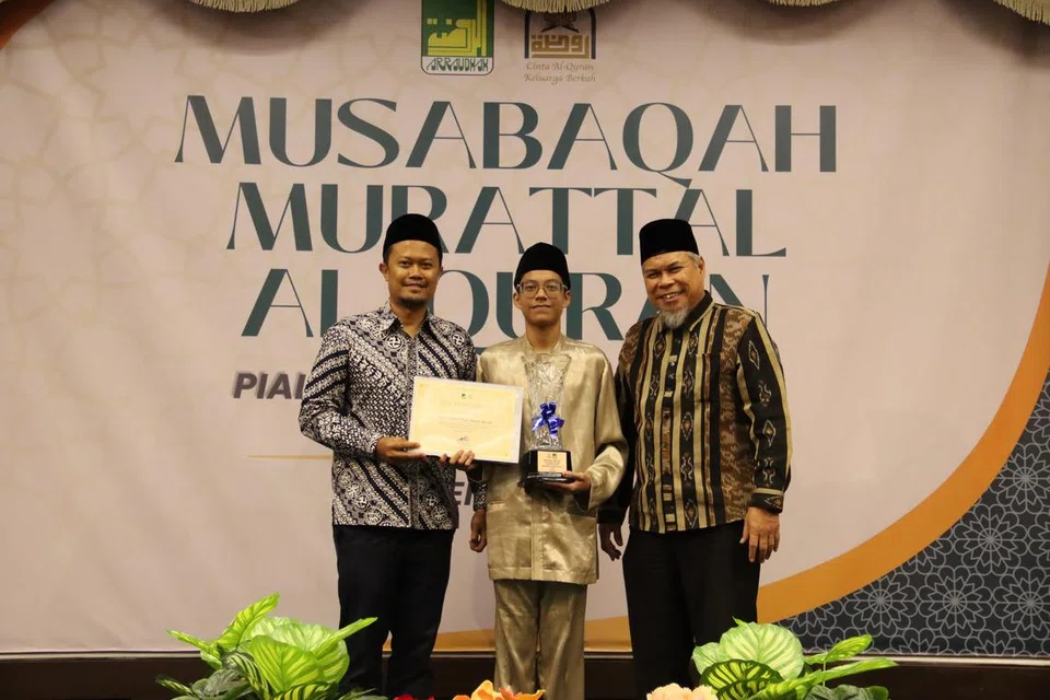 Pemenang pertama, atau Juara Qari, bagi Musabaqah Murattal Al-Quran bagi golongan belia pada tahun 2024 ini ialah pelajar Md Deen Nur Matiin Mozlee (tengah). Beliau bergambar bersama Pengerusi Eksekutif Kanan Masjid Ar-Raudhah, Ustaz Mohamed Ali Atan (kanan) dan Encik Ahmad Farid Mohd Fadzuli. 