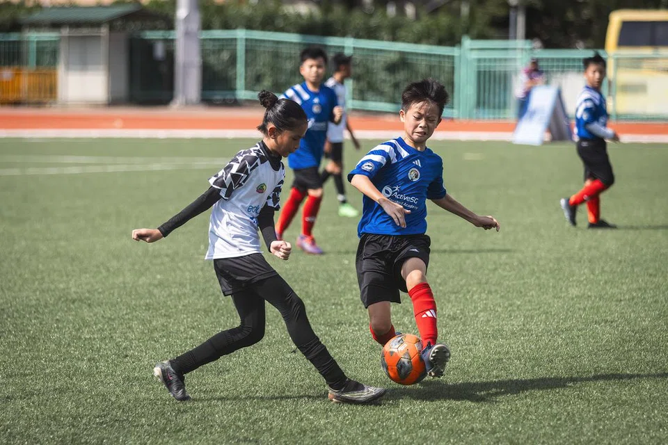 Pemain Flair Football Academy (kiri) dan pemain Balestier Khalsa AFA bersaing untuk mendapatkan bola dalam perlawanan Bawah 12-Tahun Liga Belia Singapura (SYL) di Stadium Serangoon pada 24 Februari.