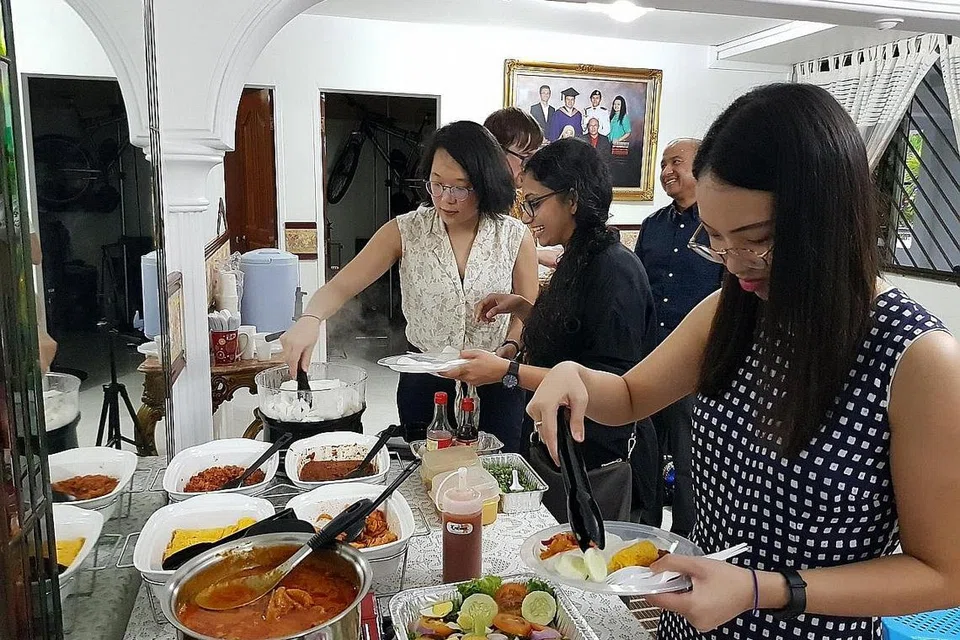 RUMAH TERBUKA: Teman-temannya yang terdiri dari pelbagai bangsa dan agama menjamu selera di rumah terbuka Encik Muhammad Ruzaini Naim Azman, 30 tahun, siswa Sekolah Dasar Awam Lee Kuan Yew (LKYSPP) - meneruskan tradisi yang dimulakan ibu bapanya sejak 1986. Menurut Encik Ruzaini, tahun ini beliau turut menjemput profesor dan teman-teman dari LKYSPP dan memperkenalkan mereka kepada juadah seperti roti kirai buatan ibunya sendiri. - Foto ihsan MUHAMMAD RUZAINI NAIM BIN AZMAN 