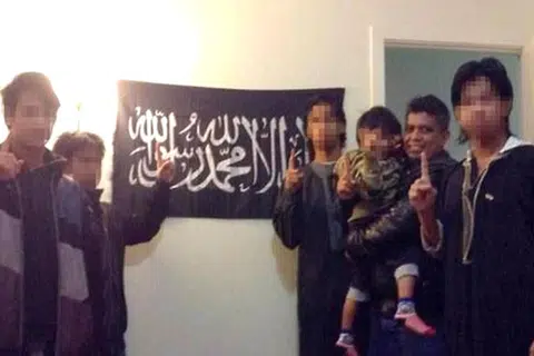 Gambar yang dimuat naik di laman sosial Facebook Zulfikar Mohamad Shariff, yang memaparkan beliau bersama anak-anaknya di hadapan bendera kumpulan pengganas ISIS.