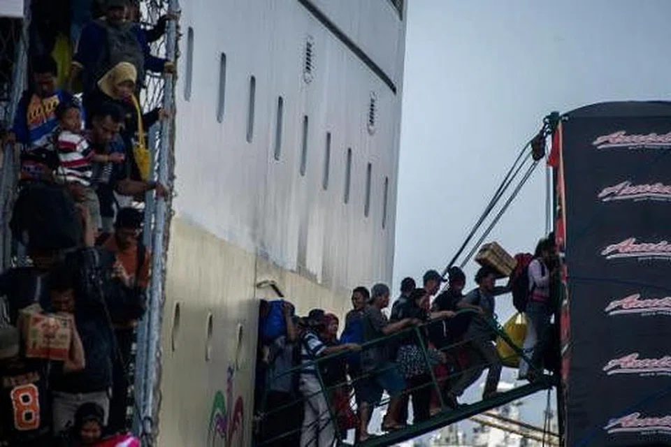 TAK ADA KERETA API, KAPAL PUN JADI: Sebuah kapal yang sarat membawa penumpang Islam yang ingin pulang ke desa 'memuntahkan' isinya sejurus tiba di dermaga pelabuhan Surabaya di Timur Jawa. - Foto AFP