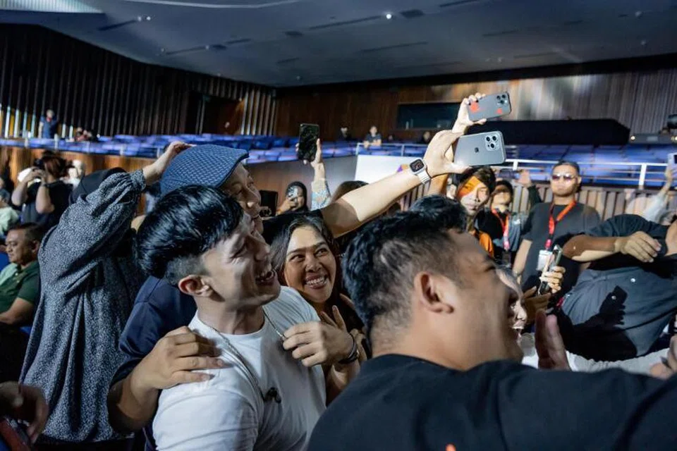 LAYAN PEMINAT DENGAN MESRA: Vokalis band Repvblik, Ruri Herdian Wantogia (berbaju putih), memberi ruang buat penonton bergambar dengannya selepas turun dari pentas untuk berinteraksi mesra. 