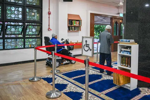 LALUAN KHAS:Tikar getah diletakkan di atas permaidani di bahagian ruang solat yang dilalui jemaah yang menggunakan kerusi roda atau skuter elektrik. 