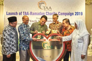 RINGANKAN BEBAN: Encik Zaqy (tiga dari kiri) bersama (dari kiri) Encik Harmizan dan anggota-anggota lembaga pengamanah Encik Ameerali Abdeali, Encik Izzuddin Taherally, Encik Hamsani Raoh dan Cik Fatimah Azimullah bersama-sama melancarkan kempen Ramadan TAA tahun ini di Orange Ballroom, Tanjong Katong Complex semalam. - Foto BH oleh ROSLEE ABDUL RAZAK