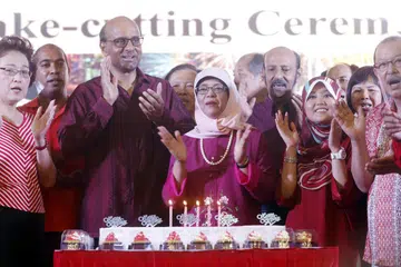 Encik Tharman Shanmugaratnam bersama Presiden Halimah Yacob semasa menghadiri satu jamuan malam sempena Hari Kebangsaan pada di Bukit Batok pada 2015.